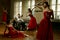 Handsome male playing on cello and four ballerina in red dress dancing around him