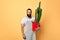 Handsome maler florist dressed in apron with a flower looking at the camera
