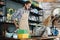 Handsome man in apron working on laptop at store