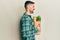 Handsome man with beard holding paper bag with groceries looking to side, relax profile pose with natural face and confident smile