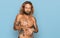 Handsome man with beard and long hair standing shirtless showing tattoos disgusted expression, displeased and fearful doing