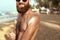 Handsome Man with beard, In Sunglasses Sunbathing With Sunscreen Lotion Body In Summer. Male Fitness Model Tanning Using Solar Blo