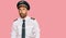 Handsome man with beard wearing airplane pilot uniform making fish face with lips, crazy and comical gesture