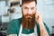 Handsome man with beard in white apron touching his moustache