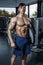 Handsome man with big muscles, posing at the camera in the gym