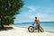 Handsome Man With Bike Sun Tanning On Beach. Summer Vacation.