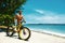 Handsome Man With Bike Sun Tanning On Beach. Summer Vacation.