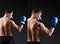 Handsome man boxer before and after retouch. Sport man back. Muscular man in boxing gloves in bixing rack on dark