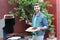 A handsome man cooking chicken and sausages on the barbecue grill