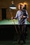 Handsome man with cue and beer near pool billiard table. American pool billiard. Billiard sport