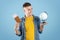 Handsome man with documents and globe ready for journey around world on blue studio background