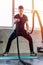 Handsome man doing battle ropes exercise workout it best cardio at fitness gym