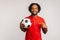 Handsome man with dreadlocks wearing red casual style T-shirt,pointing finger at soccer ball on his hand with smiling positive
