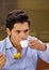 Handsome man drinking a cup of coffe and eating a delicious traditional turkish food baklava and on a brown background