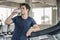 Handsome man drinks water in gym. Sports nutrition concept