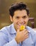 Handsome man eating a delicious traditional turkish food baklava on a brown background