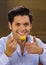 Handsome man eating a delicious traditional turkish food baklava on a brown background