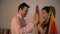 Handsome man gifting gold bangles to his beautiful wife on the Diwali festival