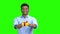 Handsome man giving gift box on green screen.