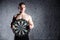 Handsome man in the gym holding a dartboard target. The concept of success and achievement of goals, results