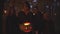 Handsome man holding halloween pumpkin with a light inside, three girls standing near. People with scary makeup on faces