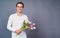 Handsome man holds pink and white tulips