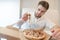 A handsome man holds a slender of appetizing pizza in his hands and stares at her with a hungry look.