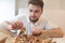 A handsome man with a hungry look tightens a piece of pizza out of the box and is about to eat it.