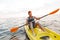 Handsome man kayaking on lake sea in boat.