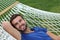 Handsome man laying in hammock and smiling