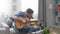 Handsome man learning to play acoustic guitar