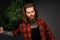 Handsome man with long hair holding a synthetic christmas tree