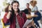 Handsome man with long hair listening music with headset and digital tablet with friends in background