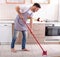 Handsome man mopping kitchen floor