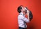 Handsome man in pink shirt with rolled sleeves holding and kissing muzzle cute gray and white cat