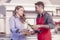 Handsome man pours red wine to his wife in the kitchen