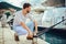 Handsome man preparing boat to start a journey at the pier