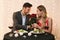 Handsome Man Presenting Roses To Happy Girlfriend On Date In Restaurant