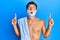 Handsome man saving beard with shave foam over face amazed and surprised looking up and pointing with fingers and raised arms