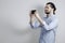 Handsome man in a shirt. takes on the phone. Long hair. Gray background