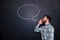 Handsome man shouting against chalkboard background with drawn speech bubble