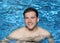 Handsome man smiling in summer pool