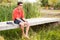 Handsome man standing on a bridge by the lake