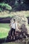 Handsome man standing near rock wearing blue goggle, sun glasses, white shirt, black pant trouser in the lake green water on sunny