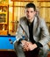 Handsome man with suit sitting in billiard pool