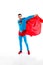 handsome man in superhero costume and cloak looking at camera
