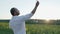 Handsome man throws paper airplane to the sunset in sunflowers field