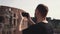 Handsome man tourist visiting Rome, Italy take photos of Colosseum. Landscape with tourists on background. Slow motion.