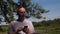 Handsome man typing message on mobile phone in on trees and pond landscape