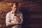 Handsome man wearing checkered shirt in wooden rural house interior